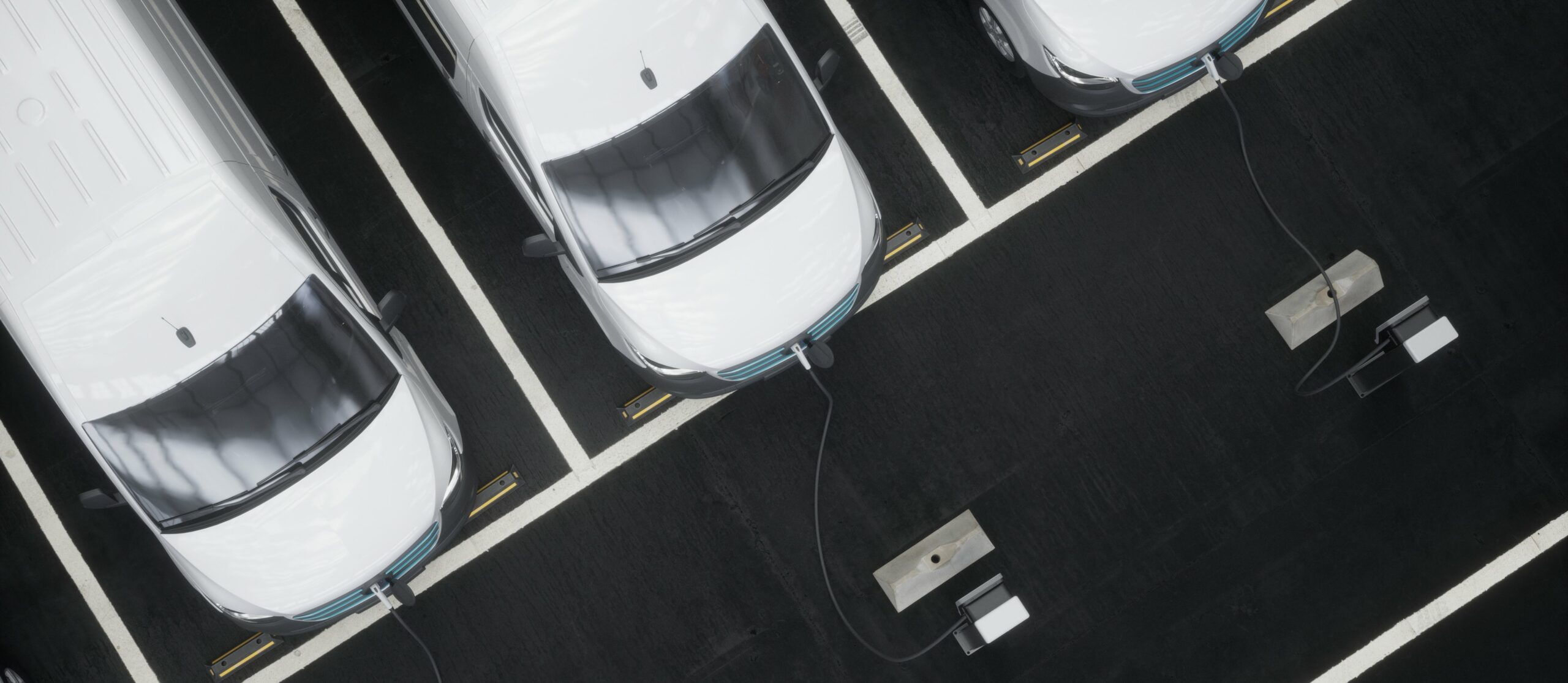white vehicles plugged into EV chargers in parking lot